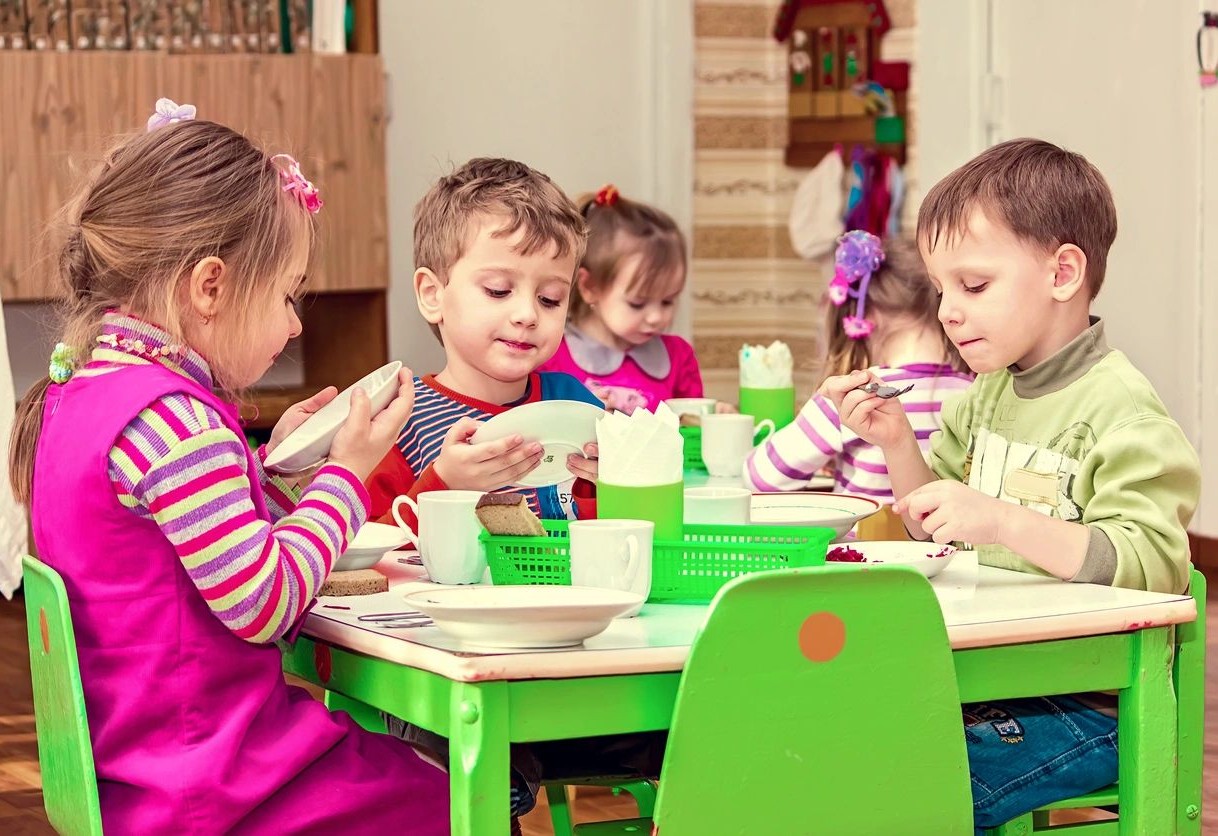 A group of children sitting at a table eating.