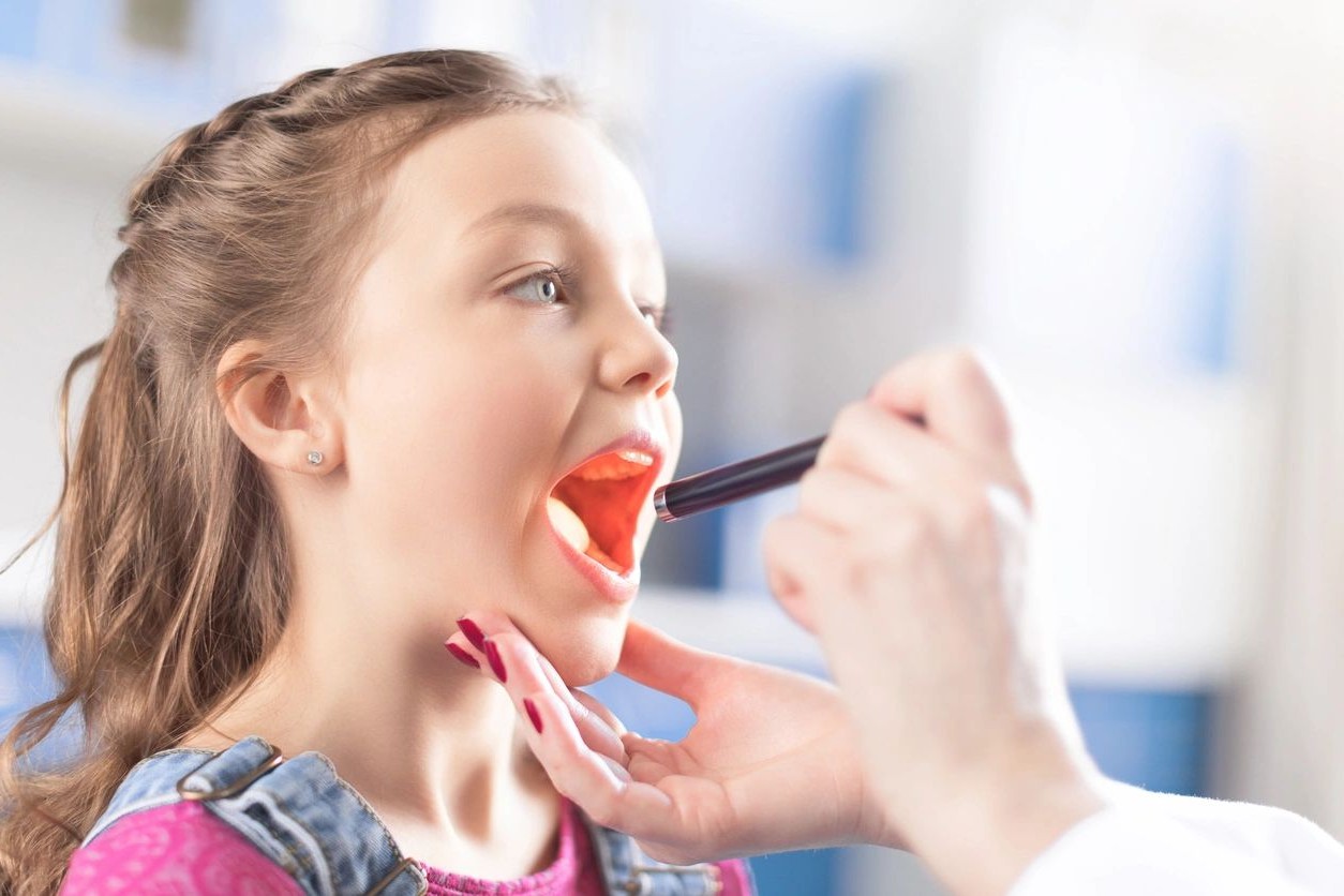 A girl is being examined by an expert dentist.